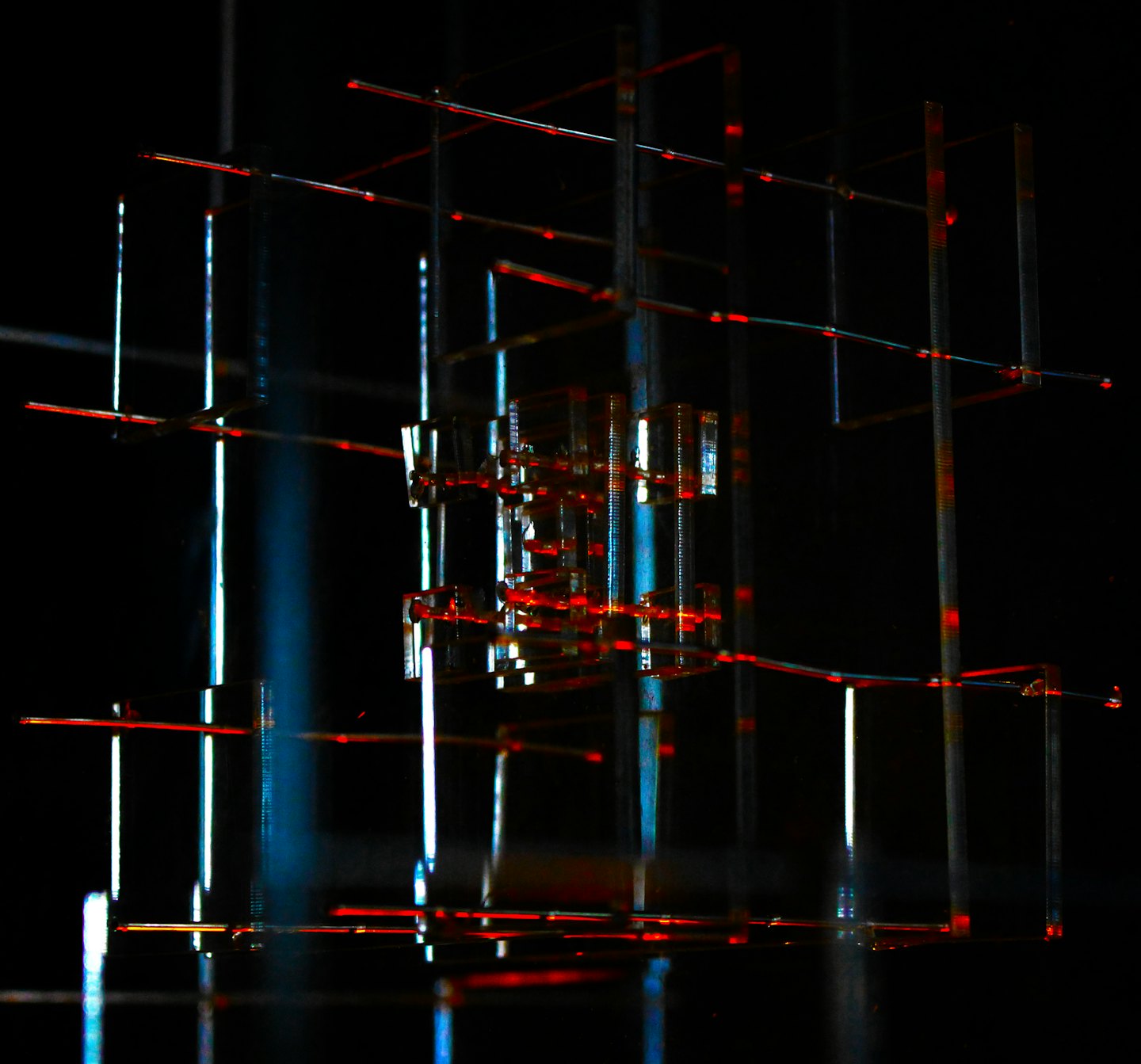 Intricate structure of glowing red and blue interconnected rods.