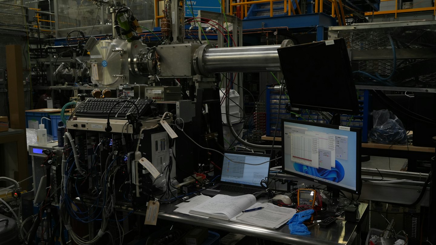 Scientists working with complex laboratory equipment and computers.